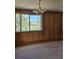 Inviting living room featuring wood paneling, a large window with mountain views, and classic chandelier at 3841 Myers Gulch Rd, Kittredge, CO 80457