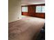 Living room with wood walls and two windows at 3841 Myers Gulch Rd, Kittredge, CO 80457