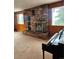 Living room with brick fireplace, two windows, and piano at 3841 Myers Gulch Rd, Kittredge, CO 80457
