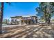 Large home featuring a spacious backyard with a deck, lush trees, and a patio at 2049 Silverheels Dr, Larkspur, CO 80118