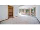 Bright, carpeted bedroom with a walk-in closet and multiple windows offering serene outdoor views at 2049 Silverheels Dr, Larkspur, CO 80118