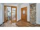 Welcoming foyer with hardwood floors, decorative doors, and a stone accent wall at 2049 Silverheels Dr, Larkspur, CO 80118