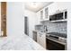 Updated kitchen with stainless steel appliances, white cabinets, and a decorative backsplash at 3035 Oneal Pkwy # 20V, Boulder, CO 80301