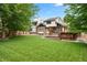 Expansive backyard with lush lawn and mature trees, complemented by a deck perfect for outdoor entertaining at 7703 S Grape Ct, Centennial, CO 80122