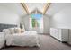 Vaulted bedroom featuring exposed wood beams, ample natural light, and neutral decor at 7703 S Grape Ct, Centennial, CO 80122