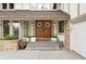Close-up of the entrance featuring a double wooden door with decorative wreaths and manicured landscaping at 7703 S Grape Ct, Centennial, CO 80122