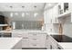 Well-appointed kitchen featuring white cabinetry, quartz countertops, modern appliances, and a view of the living area at 7703 S Grape Ct, Centennial, CO 80122