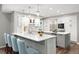 Modern kitchen with white cabinets, stainless steel appliances, quartz countertops, and an island with bar seating at 7703 S Grape Ct, Centennial, CO 80122