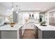 Gourmet kitchen showcasing white cabinets, quartz countertops, stainless steel appliances, and a seamless connection to the living room at 7703 S Grape Ct, Centennial, CO 80122