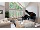Elegant living room with large windows, plantation shutters, a grand piano, and comfortable seating at 7703 S Grape Ct, Centennial, CO 80122