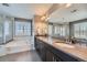 A luxurious bathroom features a double vanity, a soaking tub with marble surround, and a glass-enclosed shower at 10178 Nadine Ave, Parker, CO 80134