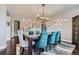 Elegant dining room with a large table, upholstered chairs, modern lighting and a stylish rug on hardwood floors at 10178 Nadine Ave, Parker, CO 80134