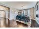 Bright dining room features hardwood floors, modern chandelier and plush green chairs around a dark wood table at 10178 Nadine Ave, Parker, CO 80134