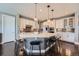 Spacious kitchen with white cabinets, mosaic backsplash, a large center island and modern pendant lighting at 10178 Nadine Ave, Parker, CO 80134