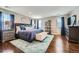 Spacious main bedroom with a blue area rug, large bed with blue bedding, and hardwood floors at 10178 Nadine Ave, Parker, CO 80134