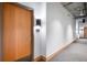 Hallway with a wooden door, wall sconce, and visible concrete ceiling at 1610 Little Raven St # 302, Denver, CO 80202