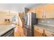 Kitchen with stainless steel refrigerator, light wood cabinets, and hardwood floors at 3126 W 112Th Ct # A, Westminster, CO 80031