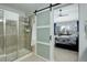 Modern bathroom with a glass-enclosed shower and a sliding door leading to the bedroom at 8338 E 148Th Way, Thornton, CO 80602
