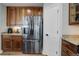 Modern kitchen featuring stainless steel refrigerator, granite countertops, and ample wood cabinet storage at 8338 E 148Th Way, Thornton, CO 80602