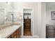 Bathroom with double sinks, a walk-in closet, a built-in dresser, and tiled floors at 681 W Burgundy St # A, Highlands Ranch, CO 80129