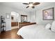 This bedroom has wood floors, a ceiling fan, an archway leading to the bathroom, and neutral colored walls at 681 W Burgundy St # A, Highlands Ranch, CO 80129