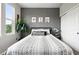 This bedroom features a gray accent wall, three large windows, and wood floors at 681 W Burgundy St # A, Highlands Ranch, CO 80129
