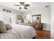 This bedroom features wood floors, a ceiling fan, dresser, and an archway leading to the bathroom at 681 W Burgundy St # A, Highlands Ranch, CO 80129