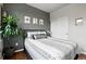 This bedroom features a gray accent wall, three large windows, and wood floors at 681 W Burgundy St # A, Highlands Ranch, CO 80129