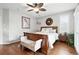 This bedroom has a wood bed frame, ceiling fan, a bench, wood floors, and neutral colored walls at 681 W Burgundy St # A, Highlands Ranch, CO 80129