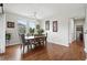 Light-filled dining room with modern lighting fixture, hardwood floors, and large windows at 681 W Burgundy St # A, Highlands Ranch, CO 80129