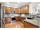 This kitchen features wood cabinets, stainless steel appliances, granite counters, and tile backsplash at 681 W Burgundy St # A, Highlands Ranch, CO 80129