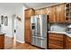 This kitchen features stainless steel appliances, wood cabinets and drawers, and wood flooring at 681 W Burgundy St # A, Highlands Ranch, CO 80129