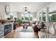 Bright living room with hardwood floors, stone fireplace, ceiling fan, and multiple windows at 681 W Burgundy St # A, Highlands Ranch, CO 80129