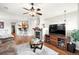 Cozy living room with fireplace, ceiling fan, hardwood floors, and mounted television on media cabinet at 681 W Burgundy St # A, Highlands Ranch, CO 80129