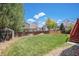 Expansive backyard with lush green lawn, wooden fence, storage shed, and mature trees at 3543 S Ceylon Way, Aurora, CO 80013