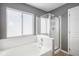 Bathroom featuring a tub, and a glass door shower in gray tones at 3543 S Ceylon Way, Aurora, CO 80013