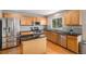 Kitchen featuring stainless steel appliances, oak cabinets, black countertops and an island with breakfast bar at 3543 S Ceylon Way, Aurora, CO 80013