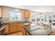 Well-lit kitchen with granite countertops, stainless steel appliances, and an adjacent dining area at 3543 S Ceylon Way, Aurora, CO 80013