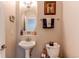 Charming half bathroom with pedestal sink, neutral walls, and decorative accents at 7087 Sapphire Pointe Blvd, Castle Rock, CO 80108