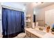 Well-lit bathroom with a shower behind a curtain, a white vanity with mirror, and white shelving at 7087 Sapphire Pointe Blvd, Castle Rock, CO 80108