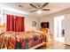 Comfortable bedroom with a ceiling fan, hardwood floors, and a window with red curtains at 7087 Sapphire Pointe Blvd, Castle Rock, CO 80108
