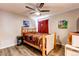 Cozy bedroom featuring a ceiling fan, hardwood floors, and vibrant artwork at 7087 Sapphire Pointe Blvd, Castle Rock, CO 80108