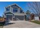 Charming two-story home with a three-car garage, gray siding, and a well-manicured front yard at 7087 Sapphire Pointe Blvd, Castle Rock, CO 80108