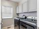 Modern laundry room with front-loading washer and dryer, complemented by ample cabinet space at 7087 Sapphire Pointe Blvd, Castle Rock, CO 80108
