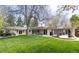 Spacious backyard with lush lawn, mature trees, and a covered patio area at 3901 S Dexter St, Cherry Hills Village, CO 80113