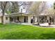 Well-manicured backyard with a patio, outdoor dining area, and mature trees at 3901 S Dexter St, Cherry Hills Village, CO 80113