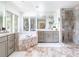 Bright bathroom featuring marble accents, a glass shower, and a soaking tub, creating a luxurious spa-like retreat at 3901 S Dexter St, Cherry Hills Village, CO 80113