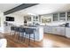 Modern kitchen features gray cabinets, stainless appliances, large island with bar seating, and hardwood floors at 3901 S Dexter St, Cherry Hills Village, CO 80113