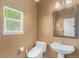 Cozy bathroom featuring a window, pedestal sink, and modern toilet, ideal for comfort and convenience at 7852 Solstice Way, Castle Rock, CO 80108