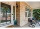 Inviting front porch with brick accents, a cozy seating area, and a decorative wreath on the front door at 7852 Solstice Way, Castle Rock, CO 80108